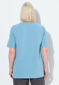 T-shirt blu chiaro a maniche corte con scollatura rotonda, texture del tessuto liscia e vestibilità comoda, esposto da dietro.