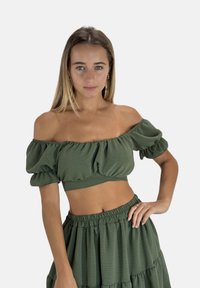 Top corto verde con hombros descubiertos y mangas abullonadas, con una tela ligera y texturizada y un diseño ajustado y fruncido.