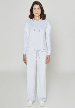 Felpa con cappuccio azzurro chiaro con coulisse, abbinata a pantaloni sportivi larghi coordinati. Entrambi realizzati in tessuto morbido con una texture confortevole.