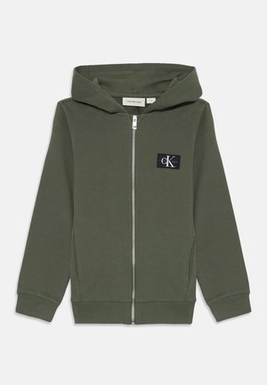 Olivgrüner Kapuzenpullover mit Reißverschluss, Fronttaschen, gerippten Bündchen und Saum, Kapuze sowie einem kleinen schwarzen Calvin Klein Jeans Logo-Patch auf der Brust.