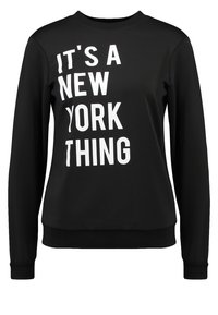 Sudadera negra de manga larga, cuello redondo y texto impreso en blanco: "ES UNA COSA DE NUEVA YORK" en diferentes tamaños de fuente. Textura suave.