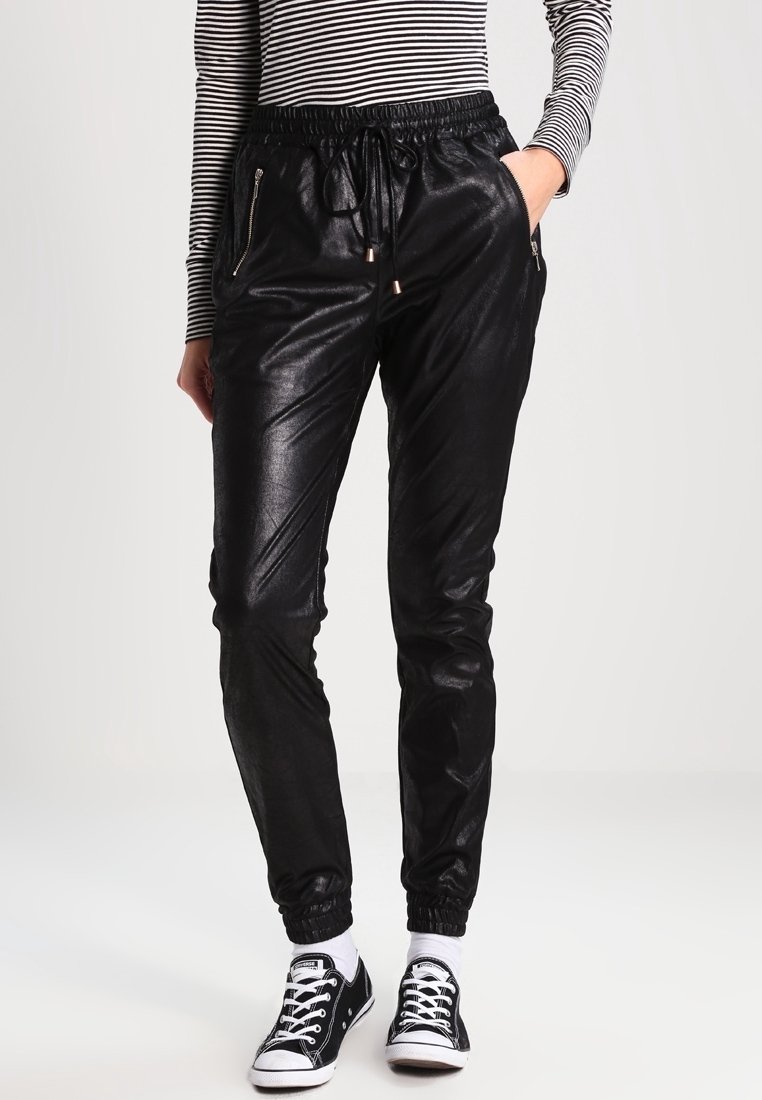 Schwarze, glänzende Jogginghose mit elastischem Bund, verstellbarem Kordelzug und Reißverschlusstaschen an den Seiten; taillierte Bündchen an den Knöcheln.