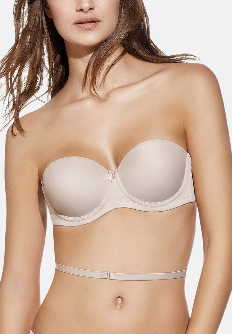 Sujetador beige sin tirantes con copas de espuma lisas y un delicado lazo en el centro. Estribillo trasero ajustable con cierre de gancho.