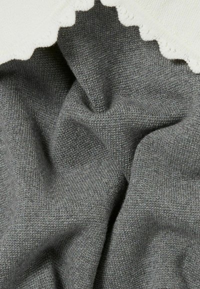 Tessuto a maglia grigio con una consistenza morbida, caratterizzato da un bordo ondulato bianco nella parte superiore. Il materiale presenta un motivo fine e uniforme.