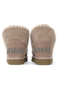 Botines de ante rosa con forro de piel suave, costuras decorativas y acentos de logo en glitter plateado en la parte posterior. Suelas de goma planas.