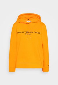 Sudadera naranja de algodón con un bolsillo tipo canguro, capucha con cordón y el logotipo impreso "TOMMY HILFIGER EST. 1985" en negro en el pecho.