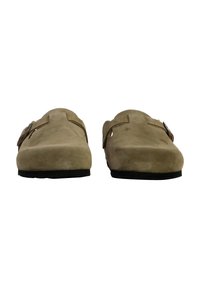 Brown suede slip-on shoes with a rounded toe, featuring a buckle accent and a textured surface, set against a white background.