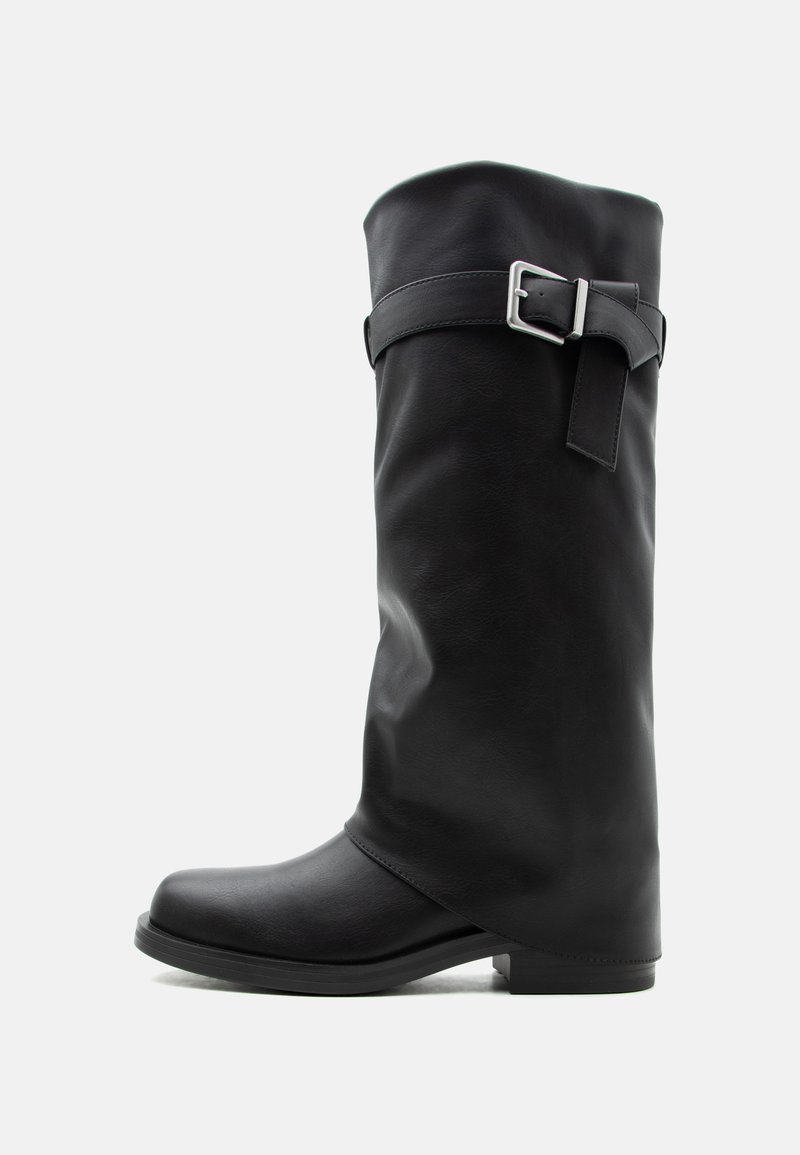 Ψηλή μαύρη δερμάτινη μπότα με ασημένιο λουράκι με αγκράφα γύρω από τον άνω γαστροκνήμιο και χαμηλό τετράγωνο τακούνι.