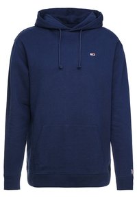 Tmavě modrá mikina s kapucí vyrobená z měkkého materiálu, s přední kapsou, stahovací kapucí a malým logem na hrudi.