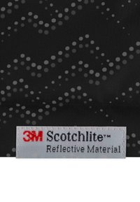 Schwarzer Stoff mit einem reflektierenden gepunkteten Muster in unterschiedlichen Grautönen. Etikett: "3M Scotchlite™ Reflexmaterial."