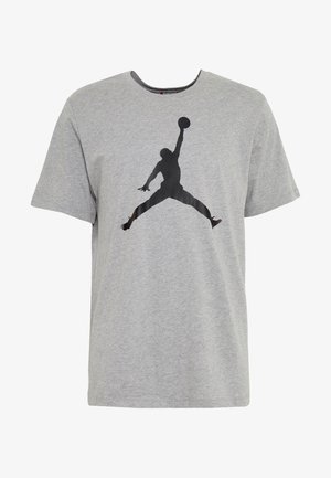 Maglietta grigia in cotone con silhouette nera di una figura che salta tenendo un pallone da basket sul davanti. Design classico con scollo rotondo.