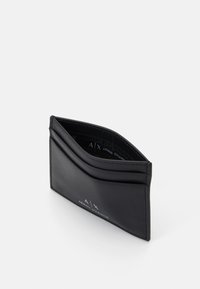 Portofel din piele neagră pentru carduri, cu mai multe sloturi, având un design elegant și un logo embosat. Textură netedă cu detalii de cusătură subtile.