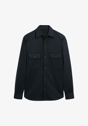 Camicia nera con bottoni realizzata in tessuto testurizzato, presenta un colletto a punta, due tasche sul petto e maniche lunghe con polsini abbottonati.