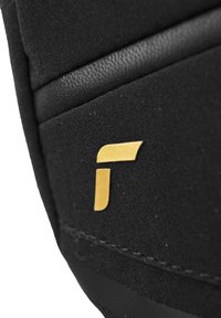 Tela negra con superficie texturizada que presenta un logotipo dorado en una fuente estilizada. Acabados lisos en negro a lo largo de los bordes, resaltando los detalles del diseño.