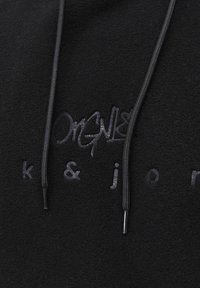 Sudadera de forro polar negra con un logo en relieve y letras del mismo color. Cuenta con cordones ajustables, con extremos lisos y brillantes.