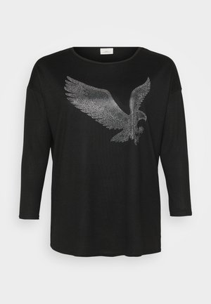 Chemise noire à manches longues ornée d'un design d'aigle scintillant en strass argentés, avec une coupe décontractée et un col rond.