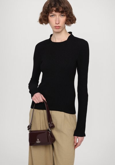 Black long-sleeve top with a subtle ribbed texture, paired with a small burgundy patent leather handbag featuring a silver logo detail.