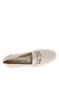 Mocassin en suède beige avec un bout arrondi, un accent en nœud central et une semelle intérieure lisse et métallique affichant le nom de la marque, Marco Tozzi.