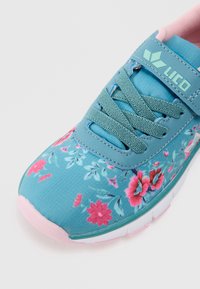 Türkise Sportschuhe mit Blumenmuster, Obermaterial aus Stoff, grauen Schnürsenkeln und pinker Gummisohle. Mit einem Logo auf dem Riemen.