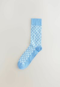 Calcetín azul claro con un diseño patternado que presenta diamantes blancos. Tejido de punto con una textura suave y puño acanalado en la parte superior.