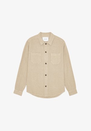 Cămașă bej cu nasturi, realizată din material texturat, cu guler, două buzunare frontale și nasturi maro. Tiv drept și mâneci lungi.