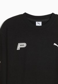 Czarny sweter o strukturze z dzianiny. Posiada biały logo "P" na lewej piersi oraz białe logo Puma na prawym ramieniu.