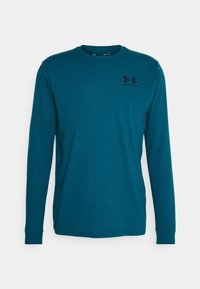 Pitkähihaisen turkoosin paidan, joka on valmistettu pehmeästä kankaasta. Siinä on pyöreä kaula-aukko ja pieni musta logo vasemmassa ylärinnassa. Suora leikkaus ja kääritty hihansuu.