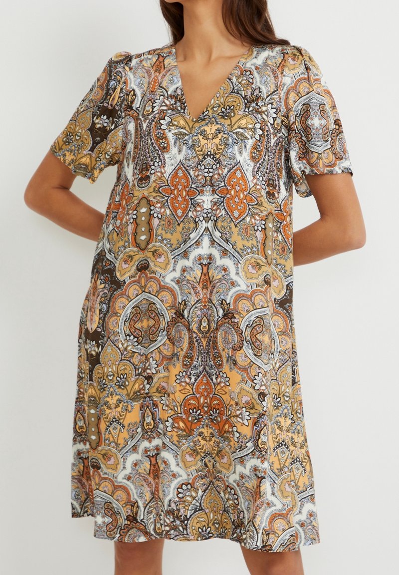 Kortärmad klänning med djup V-ringning, som har ett livligt paisleymönster i orange, brunt och vitt. Lättviktsmaterial med avslappnad passform.