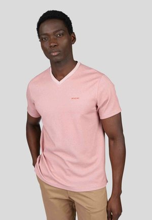 T-shirt rose clair en V fabriqué en tissu mélangé coton, avec des manches courtes et un petit détail brodé sur la poitrine.