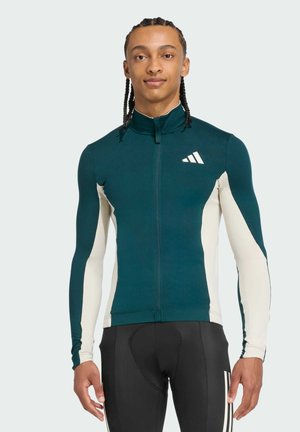 Men's long-sleeve athletic top featuring dark teal and cream panels, with a high collar and subtle logo on the chest. Smooth fabric texture.