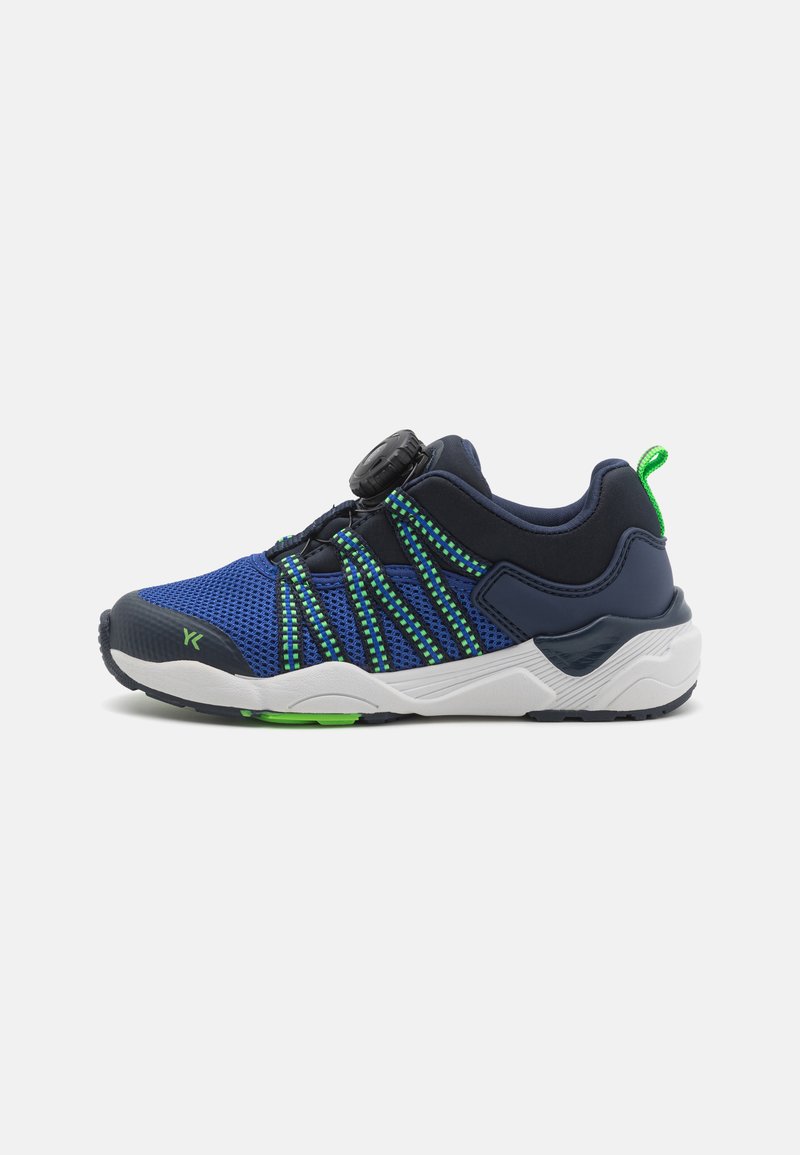 Blue mesh athletic shoe with green accents, a circular fastening, and a cushioned white sole; textured upper and adjustable elastic bands.