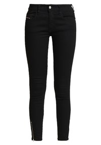 Jeans skinny negros de mezclilla, con una cinturilla alta, bolsillos delanteros y cremalleras en el tobillo para aportar detalles y ajustar el fit.