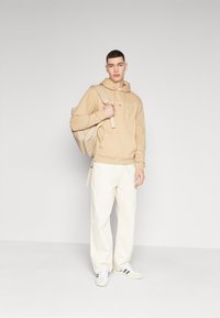Tommy Jeans LINEAR LOGO - Športni pulover - tawny sand