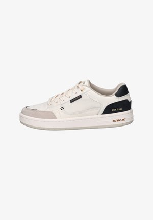 Beiger Sneaker mit weißer Sohle, schwarzem Fersenpanel mit der Aufschrift „EST. 1992“ und kleinem „Skechers“-Etikett an der Seite.