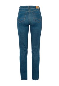 Jeans skinny en denim bleu foncé avec une texture lisse, présentant un design classique à cinq poches et une pièce en cuir marquée à la taille.