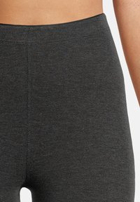 Höga svarta leggings gjorda av ett strukturerat, elastiskt material, med en sömlös design och subtila sömnadsdetaljer.