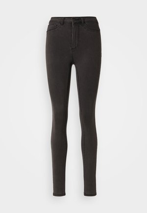 Mustad teksad mustas denimis, millel on kõrge vöökoht, vööloopid ja küljetaskud. Sile tekstuur koos peente õmblusdetailidega.
