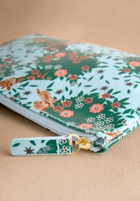 Ziedu kabatas soma ar rāvējslēdzēju, kurai ir gaiši zila fona krāsa ar zaļiem lapu motīviem, rozā un baltām puķēm, kā arī zelta rāvējslēdzēja detalizācija. Tekstūra materiāls.