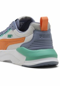 Les baskets Puma présentent une tige en mesh et synthétique dans des tons gris, orange et bleu sarcelle, avec un col rembourré, un contrefort de talon texturé et une semelle en caoutchouc.