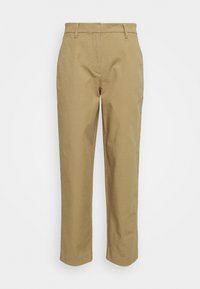 Beige suorat housut vyölenkeillä, vetoketjulla edessä ja siistillä, yksinkertaisella muotoilulla valkoista taustaa vasten.