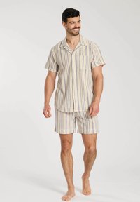 Mans kort pyjamas-set i ljusbeige med blå och krämfärgade vertikala ränder; kortärmad knäpptröja och matchande shorts. Tillverkat av bomullsmaterial.