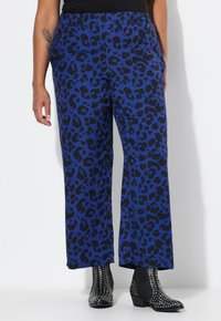 Blauwe luipaardprint wijde broek met een elastische tailleband, gecombineerd met zwarte gestikte enkellaarsjes. Glad stof met een relaxte pasvorm.