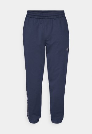Pantalones de chándal azul marino fabricados con tejido suave, que cuentan con una cintura con cordón, bolsillos laterales y un logo impreso a lo largo de la pierna izquierda.