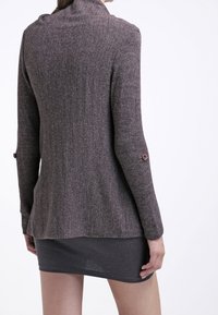 Cardigan marrone a maniche lunghe con finitura in maglia testurizzata, dotato di un colletto alto e decorazioni con bottoni sulle maniche.