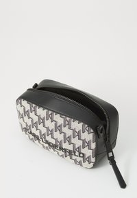 Rechthoekige cosmetica case met een zwarte leren rits en bodem, voorzien van een gestoffeerd materiaal met grijze en paarse geometrische patronen.