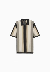 Camisa de botones de manga corta hecha de tejido de punto texturizado. Presenta un cuello negro y rayas verticales audaces en crema, beige y marrón.
