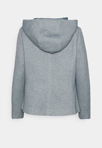 Šedá bunda s kapucí z texturované tkaniny, se strukturovaným střihem a bočními švy. Má hladkou vnitřní podšívku a žádné viditelné zapínání.