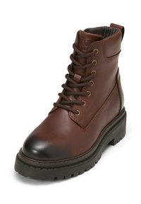 Bruine leren veterschoenen met een ronde neus, een gevoerde kraag en een robuuste zwarte zool. Bevat gouden oogjes en contrasterende stiksels.