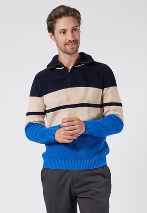 Strikket pullover med hætte, prydet med marineblå, cremefarvede og blå striber. Ribbet struktur og lynlås lukning; tætsiddende manchetter og kant.