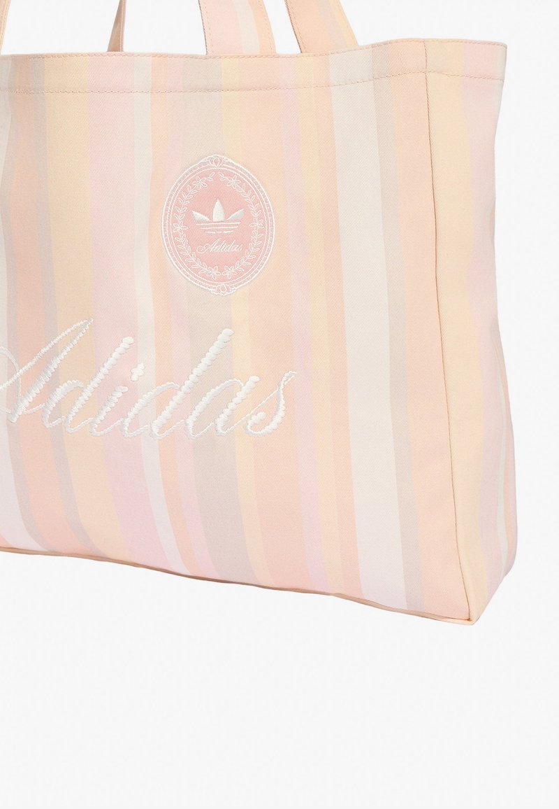 Gestreifte pastellrosa und beige Tragetasche mit gesticktem Adidas-Logo und Trefoil-Emblem in weißem Garn.